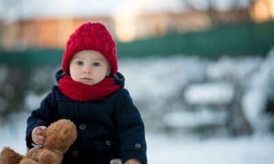 bambino gioca fuori con neve e teddy orsacchiotto