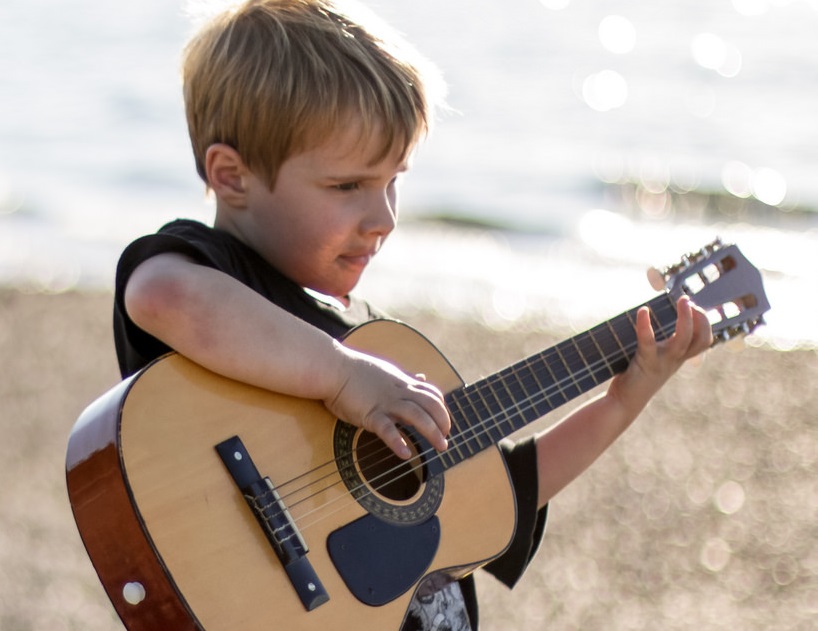 insegnare ai bambini a suonare la chitarra