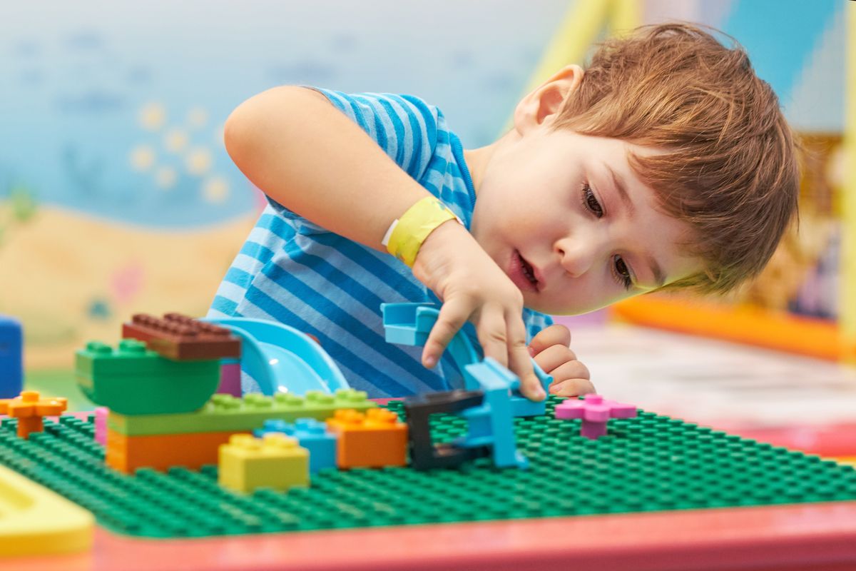 bambino gioca con i lego mattoncini colorati