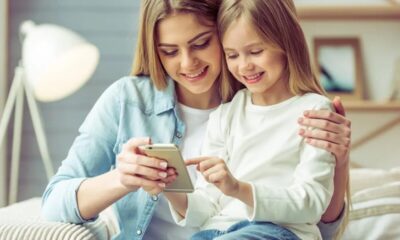 sorelle bambina ragazza divano sorriso telefono smartphone cellulare