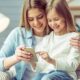 sorelle bambina ragazza divano sorriso telefono smartphone cellulare