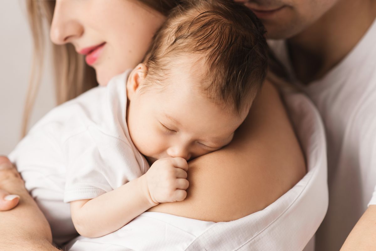 famiglia mamma e papa abbraccio neonato