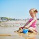 bambina spiaggia giocare con la sabbia