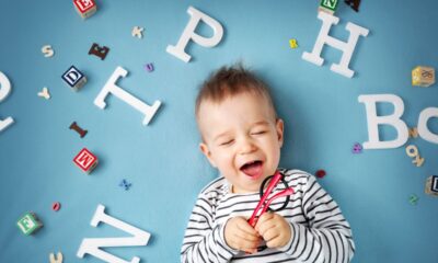 bambino sorride, giochi con lettere