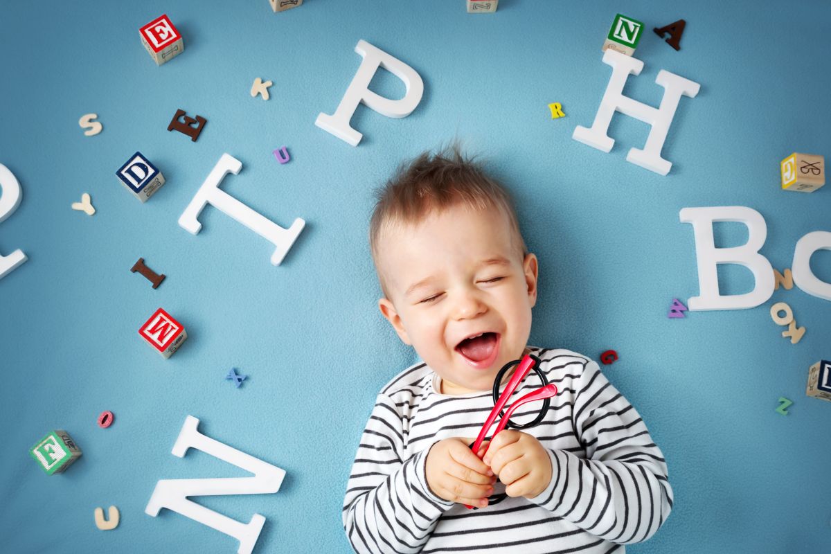 bambino sorride, giochi con lettere