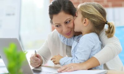 Mamma che lavora al computer con bambina