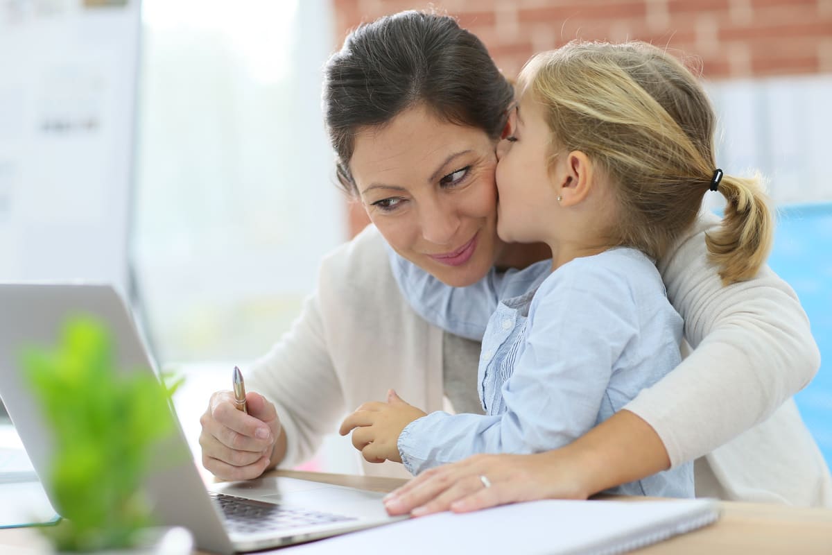 Mamma che lavora al computer con bambina