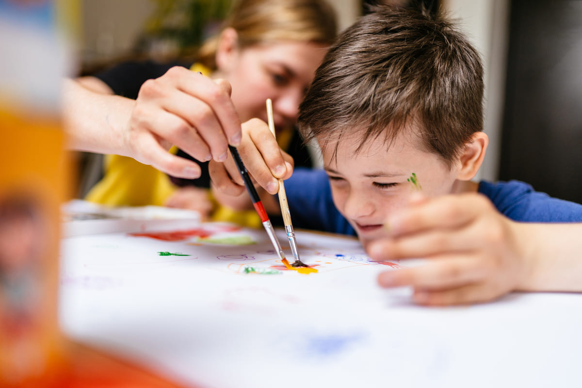 bambino con difficoltà pittura con l'insegnante