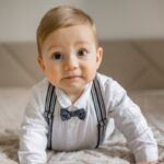 Bambino con bretelle e papillon