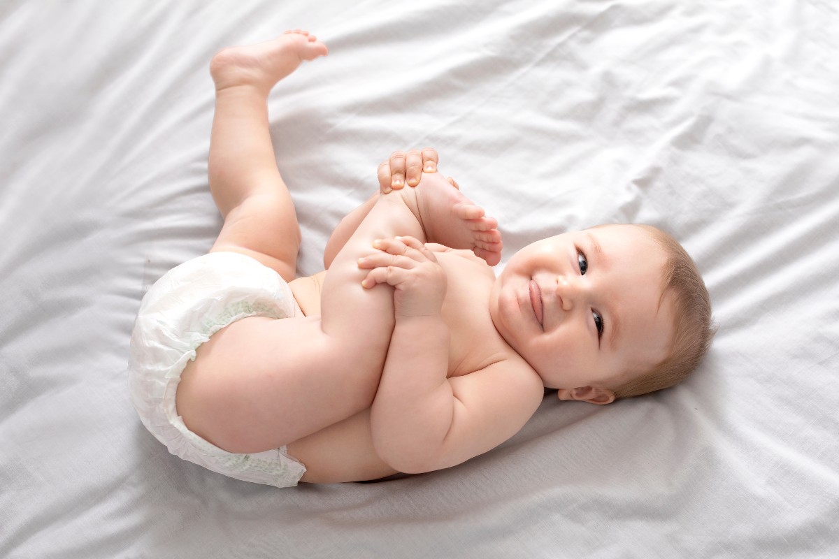 Neonato con pannolino sdraiato sul letto